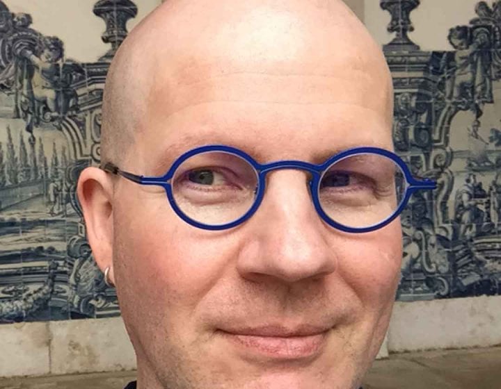 Dr Marshall Moore wearing blue-framed glasses