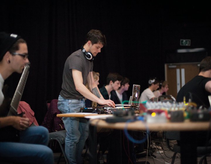 Music students at desk on mixers and laptop