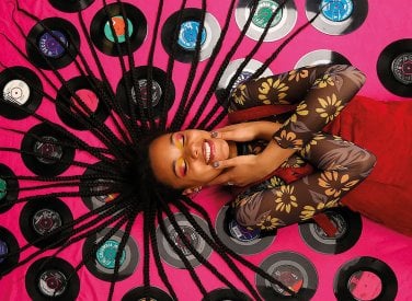 Model lying on records with hair spread out over them