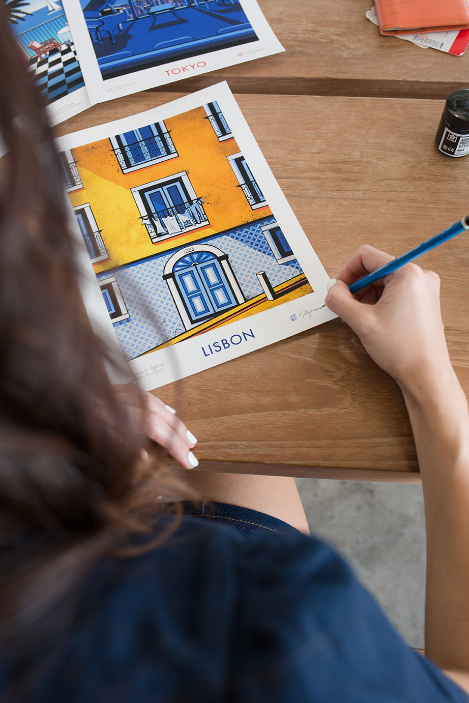 Illustrator Molly Maine signing her print 'Lisbon'