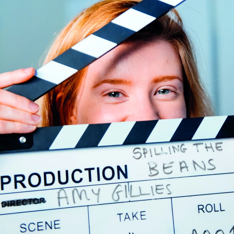 Student, Amy Gillies, peeking though a clapperboard.