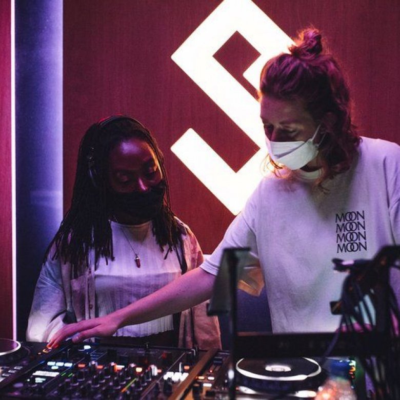 Graduate DJ Daisy Moon at the decks with another woman.