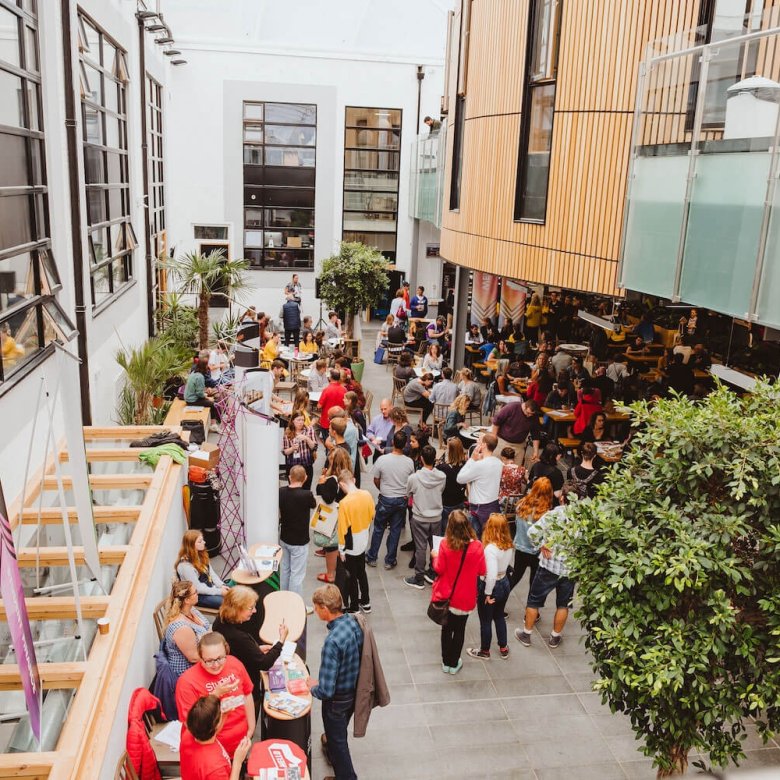 A crowd of parents and students at an Open Day inside Falmouth University's campus cafe