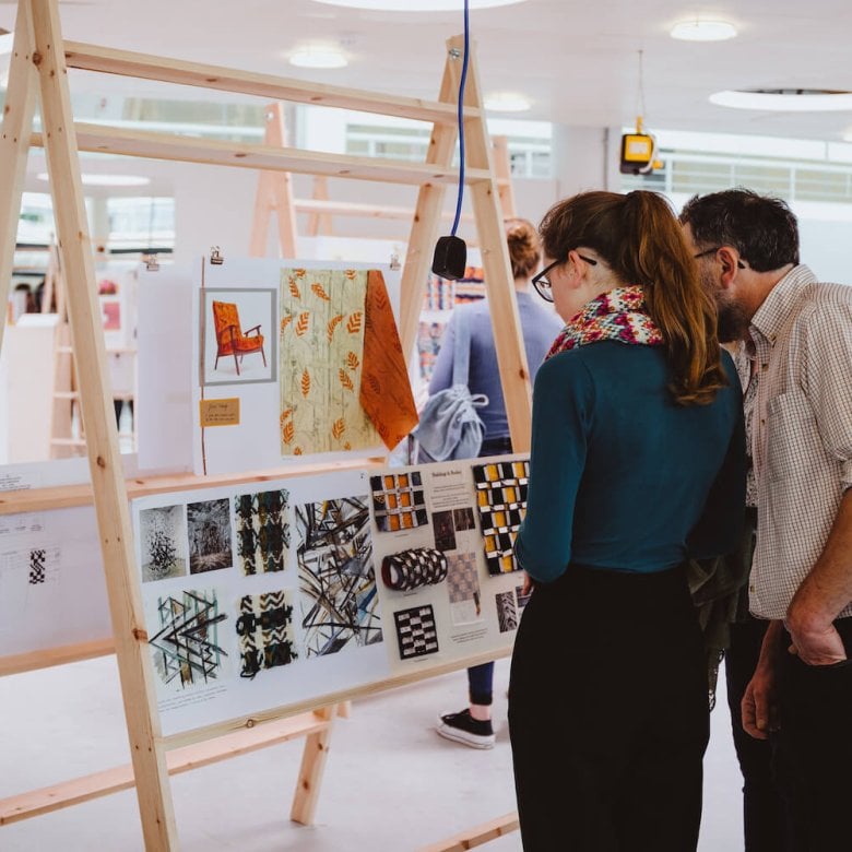 A father and daughter looking at an art exhibition at Falmouth University