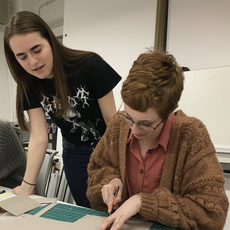 Student Hollie Milne making a model with fellow student looking on