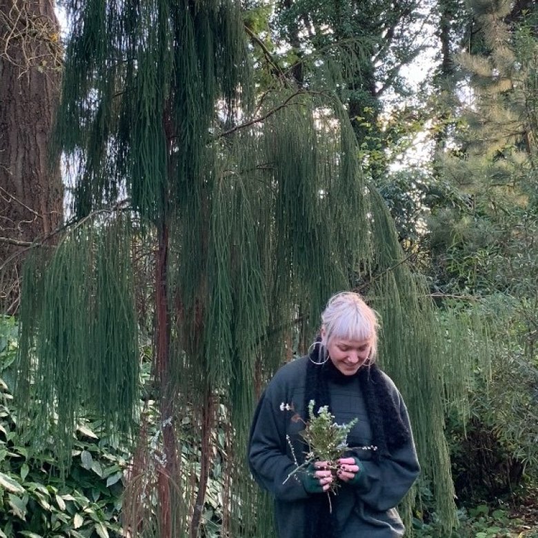 A blond woman stood in a forest