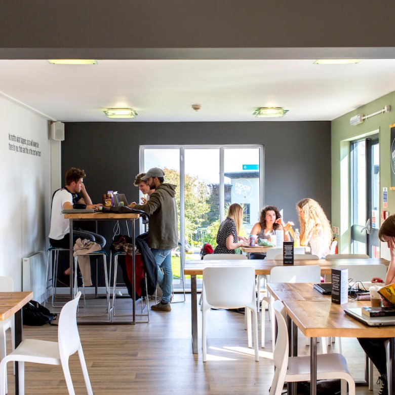 Three groups of Falmouth students sitting at tables at Koofi cafe