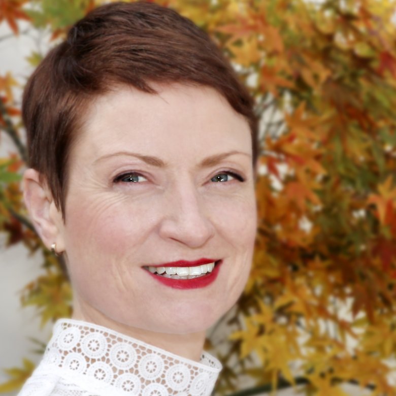 A woman with short hair smiling into the camera