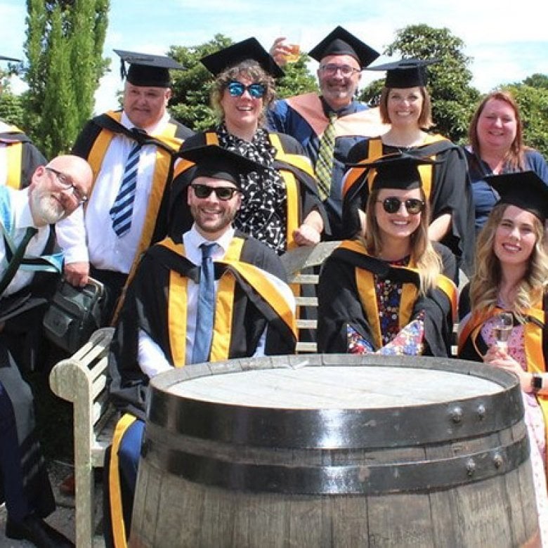 A group of Falmouth master's graduates sat together