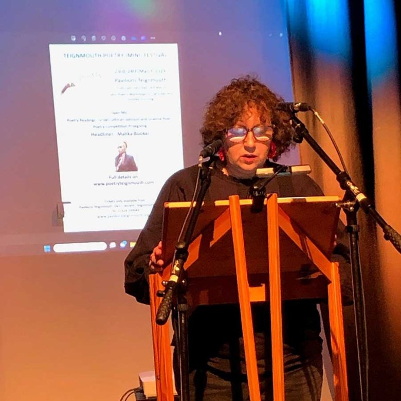 A woman stood at a pulpit reading a poem