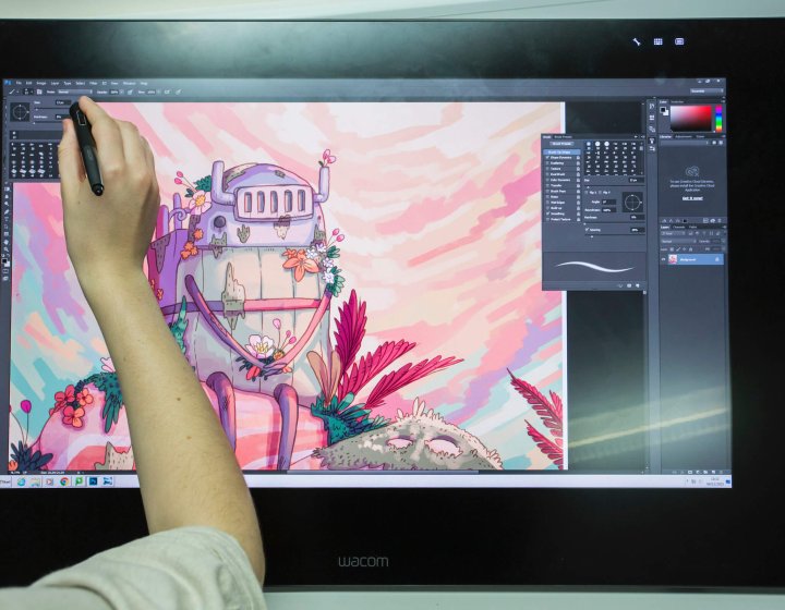 Animation student drawing a robot on a graphic tablet