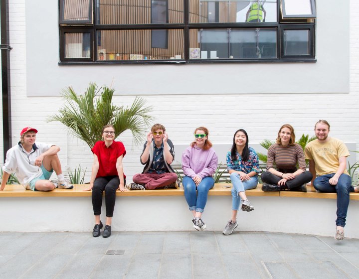 Student smiling and sitting on wall in Fox cafe.