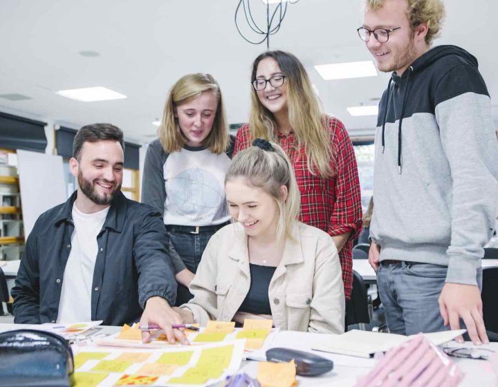 Graphic Design group of students around table