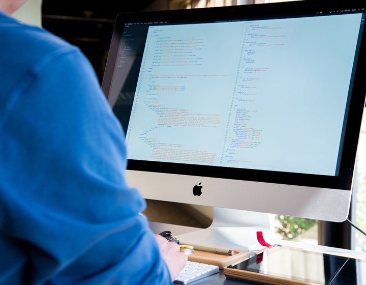 Student looking at code on an iMac.