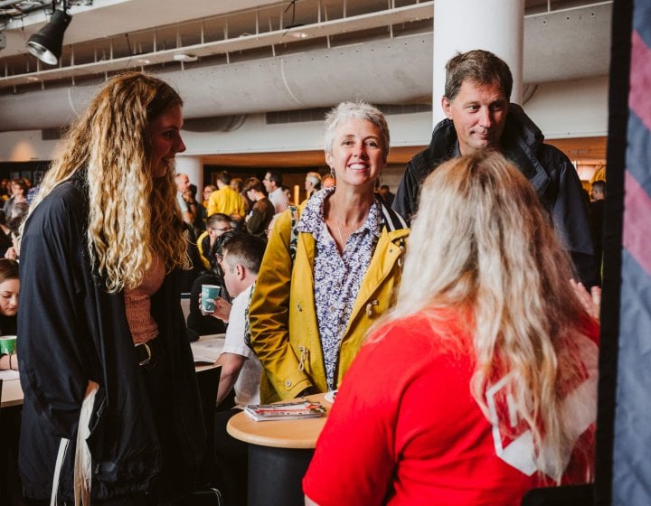 Parents smiling with daughter at an Open Day at Falmouth University