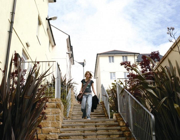 Student walking down steps between buildings.