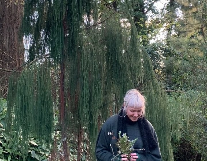 A blond woman stood in a forest