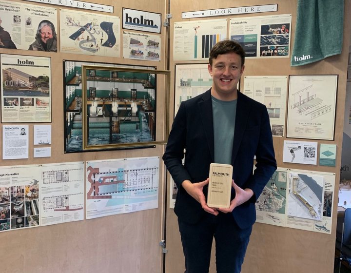 A man stands by a project display at 