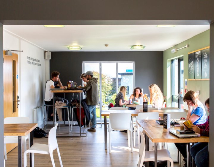 Three groups of Falmouth students sitting at tables at Koofi cafe