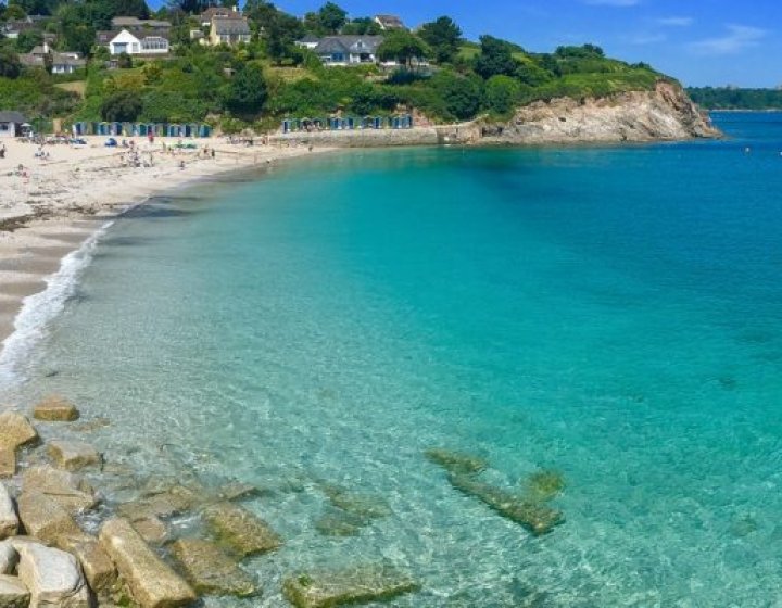 View of Swanpool Beach with turquoise water and beach huts