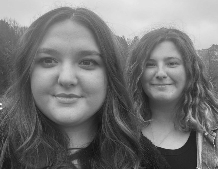 A black and white image of two people outside