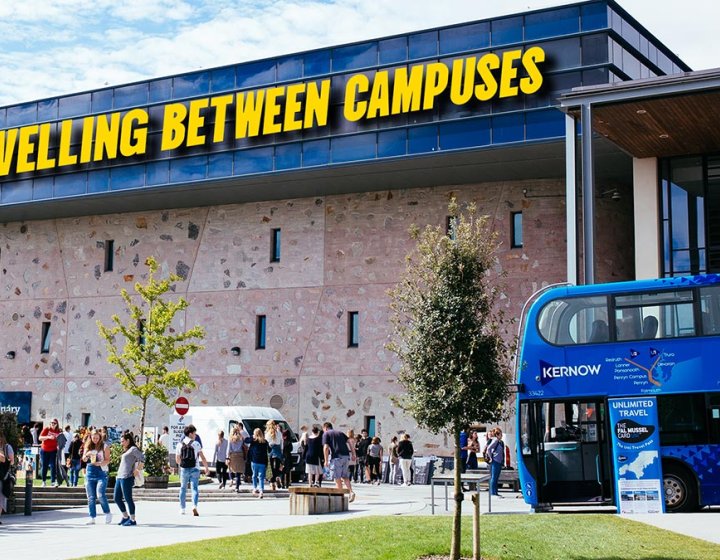 View of Penryn campus with a blue bus and the Stannary building