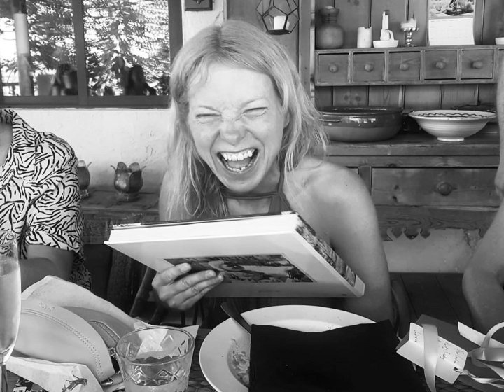 A woman smiling while holding a book 