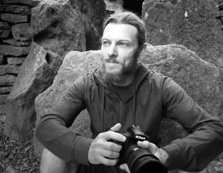 Black and white photograph of a man holding a camera