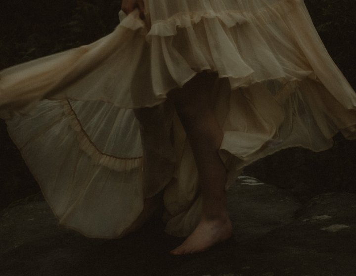 A woman's feet standing on a rock