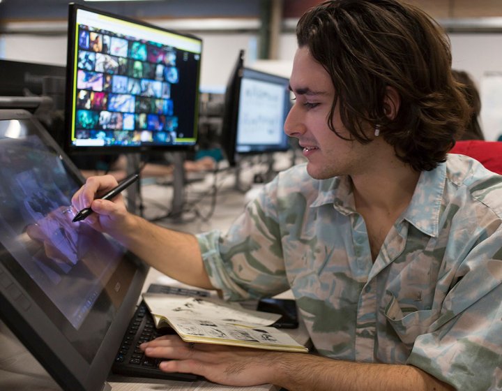 A male Game Art student from Falmouth University drawing on a digital screen