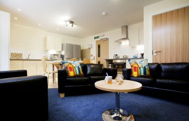 The Sidings' open-plan living area with kitchen and cluster of soft seating 