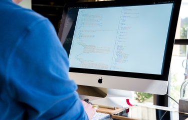 Student looking at code on an iMac.