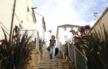 Student walking down steps between buildings.