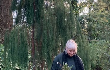 A blond woman stood in a forest