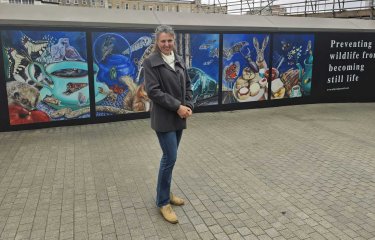 Artist and student Cindy Powell stood next to her mural of wildlife at Paddington station in London