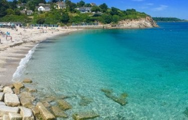 View of Swanpool Beach with turquoise water and beach huts