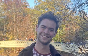 Student Tom Holmes standing in a park