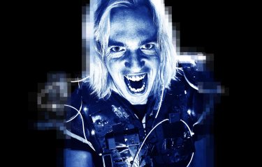 A headshot of performer John Robertson with a blue tint across the screen against a black backdrop