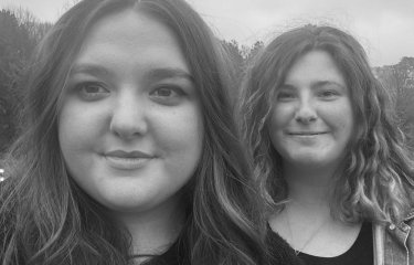 A black and white image of two people outside