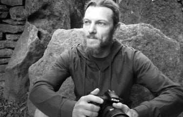 Black and white photograph of a man holding a camera