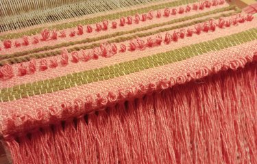 Weaving a wall hanging in progress on a table loom