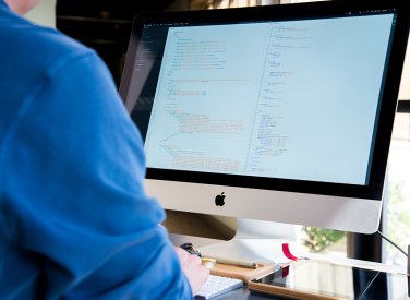 Student looking at code on an iMac.