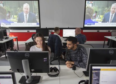 Two Falmouth University Journalism students working together at a computer
