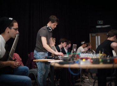 Music students at desk on mixers and laptop