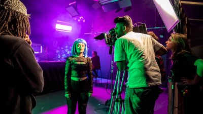 Falmouth University students in a purple lit film studio with camera