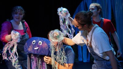Multiple performers on stage with jellyfish puppets