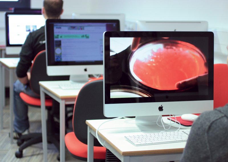 Rows of Apple Macs and students sat at some of them.