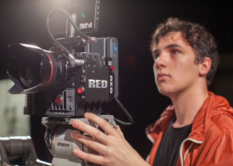 Close up of student holding film camera.