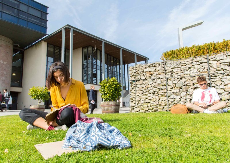 Students sit and read on the grass outside the Stannary