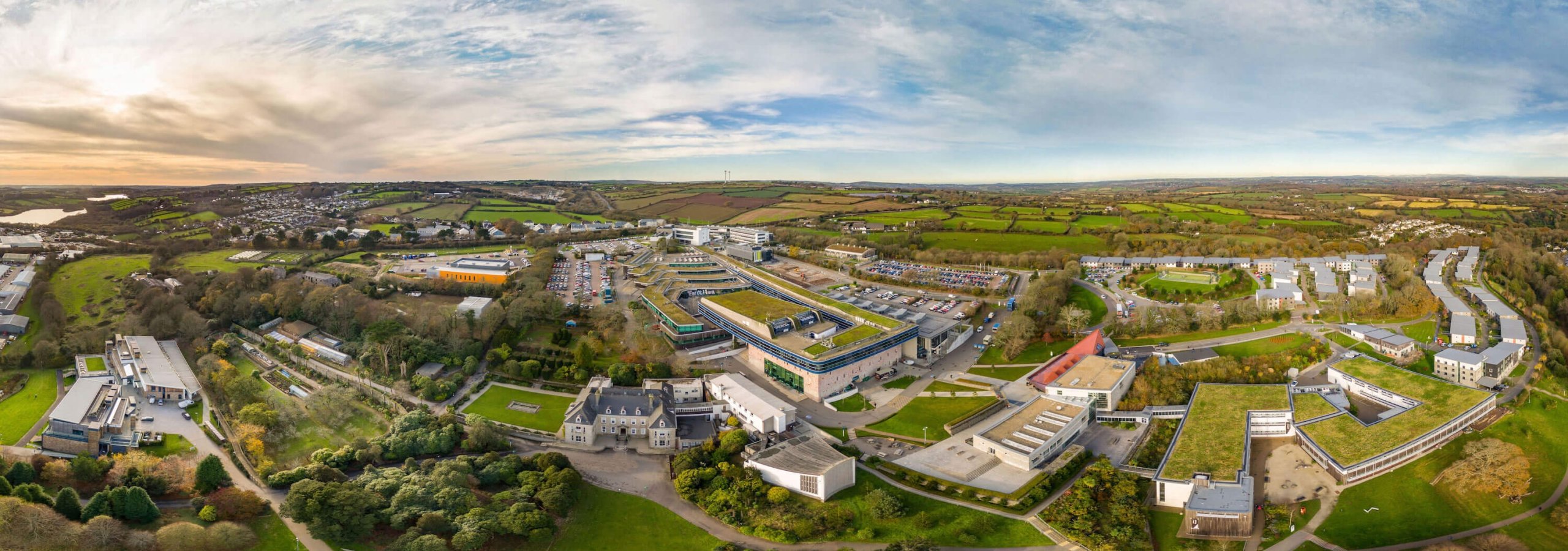 A wide angle aerial shot of Penryn campus with buildings and fields.